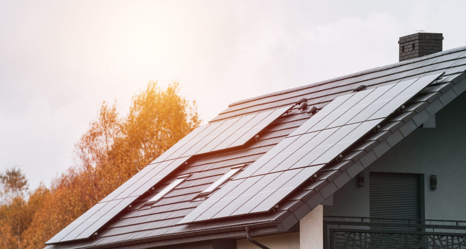 A Photo of a Modern Home with Solar Panels and Autumn Trees. A Showcase of Sustainable Living. A Sustainable and Eco-friendly Home Design.
